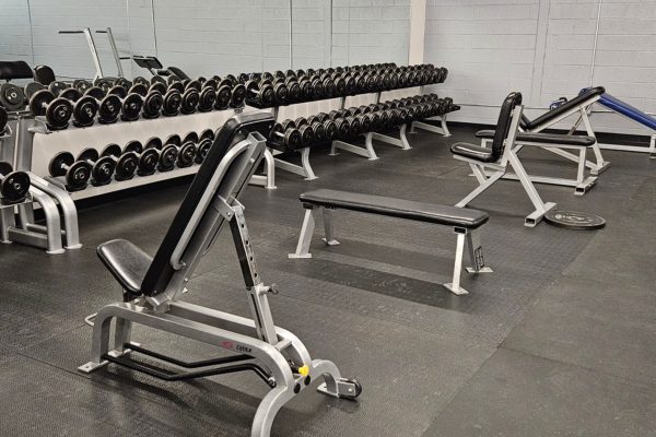 a rack of dumbells and benches for strength training at an albuquerque gym near me