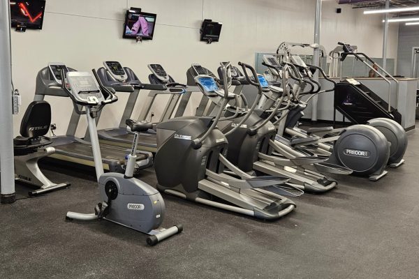 an open cardio floor with ellipticals, a stair stepper, spin machines, and treadmills at an albuquerque gym